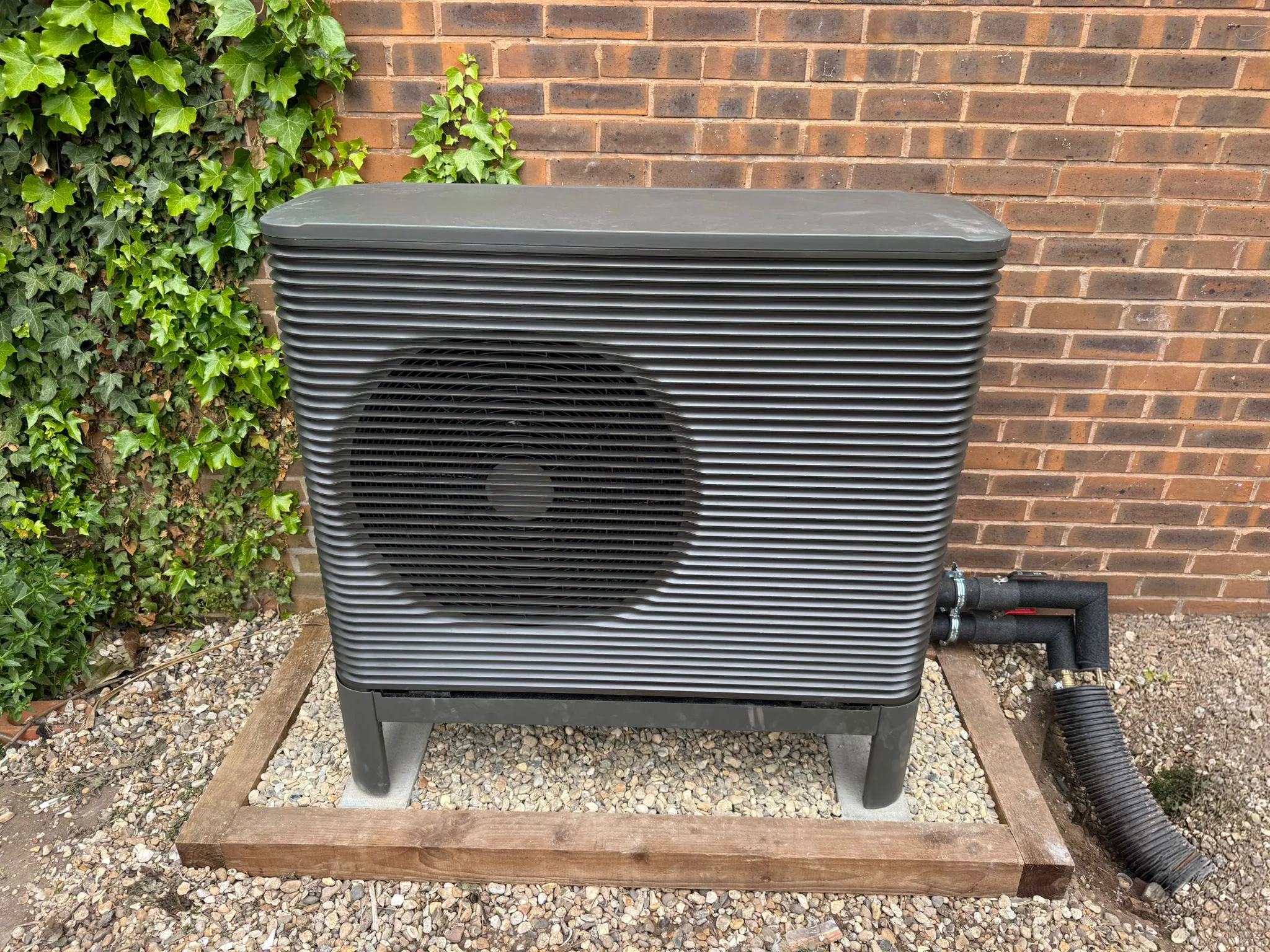 Aira air source heat pump on a custom timber base, framed into the garden, Goffs Oak